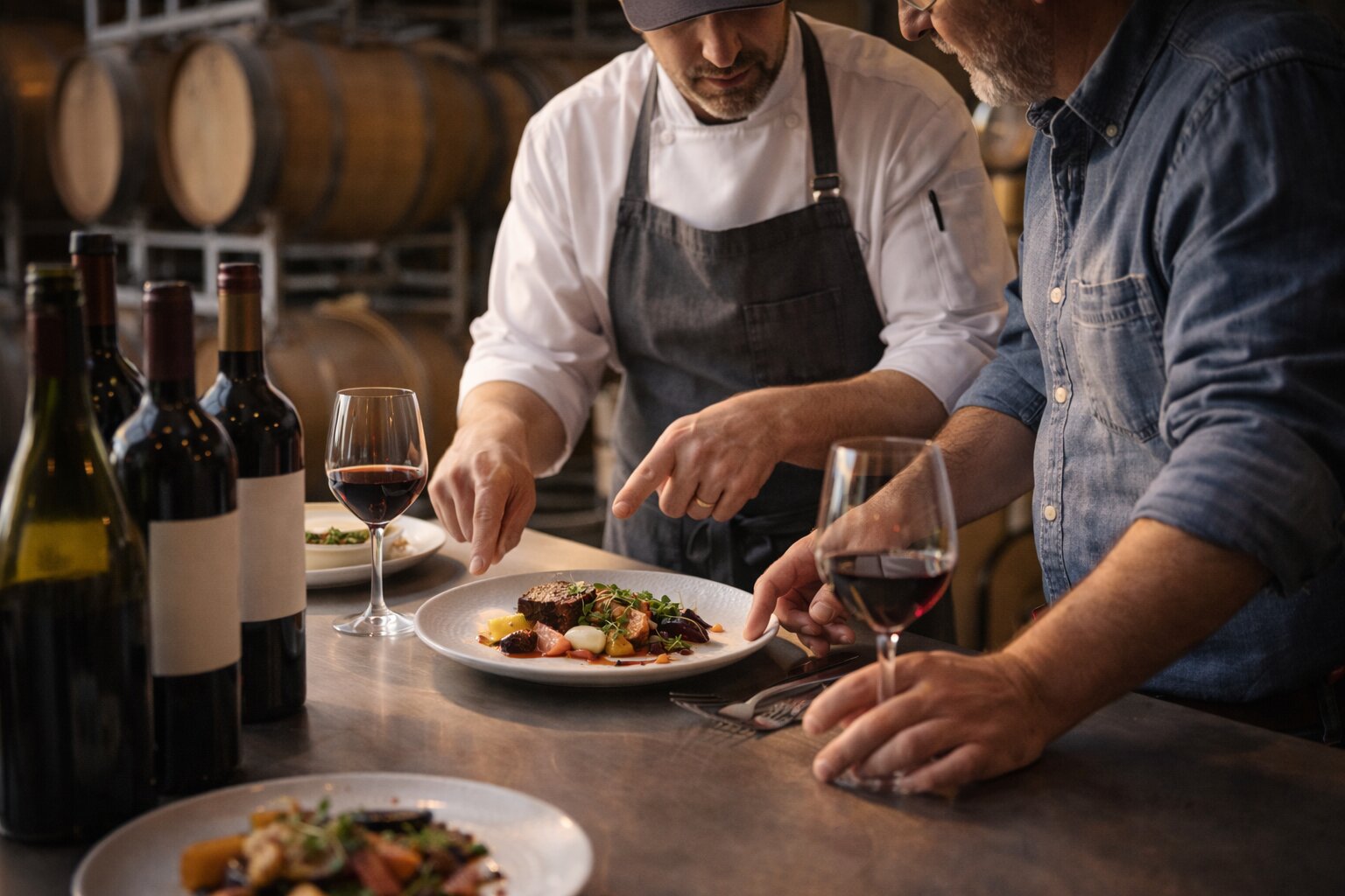 Napa Valley chef and winemaker collaborating on a wine pairing menu inside a winery setting