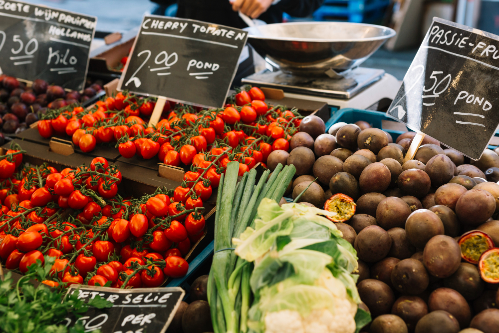 Seasonal fruits and vegetables for sale at a Napa Valley farmers market including tomatoes, peaches, and fresh greens.