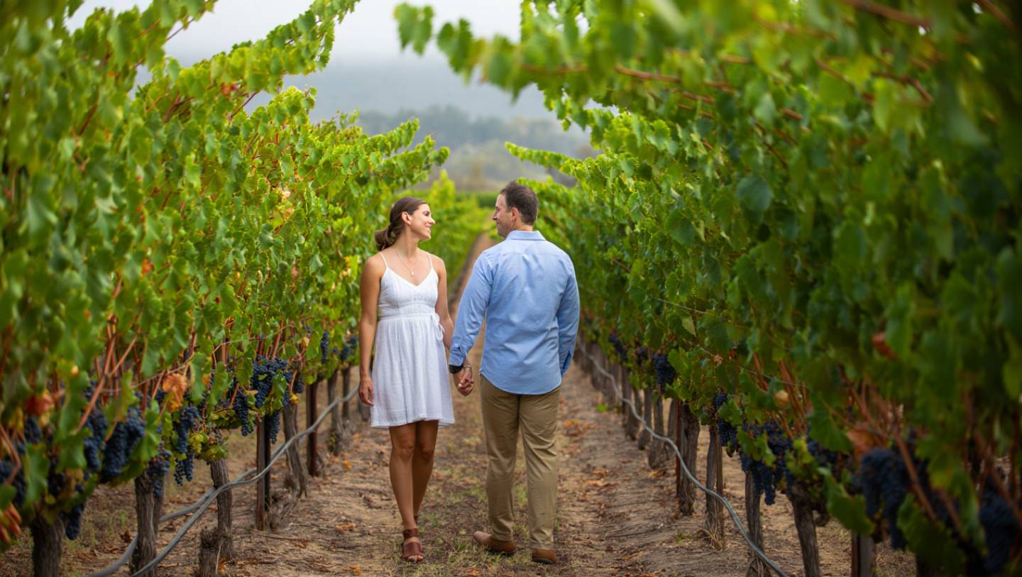 Couple walking quietly through Napa Valley vineyards, showing an intimate travel experience without crowds or staged romance.