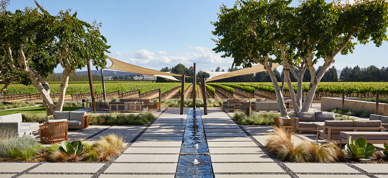 Garden courtyard at a Yountville hotel with stone walkways, fountains, and shaded seating areas.