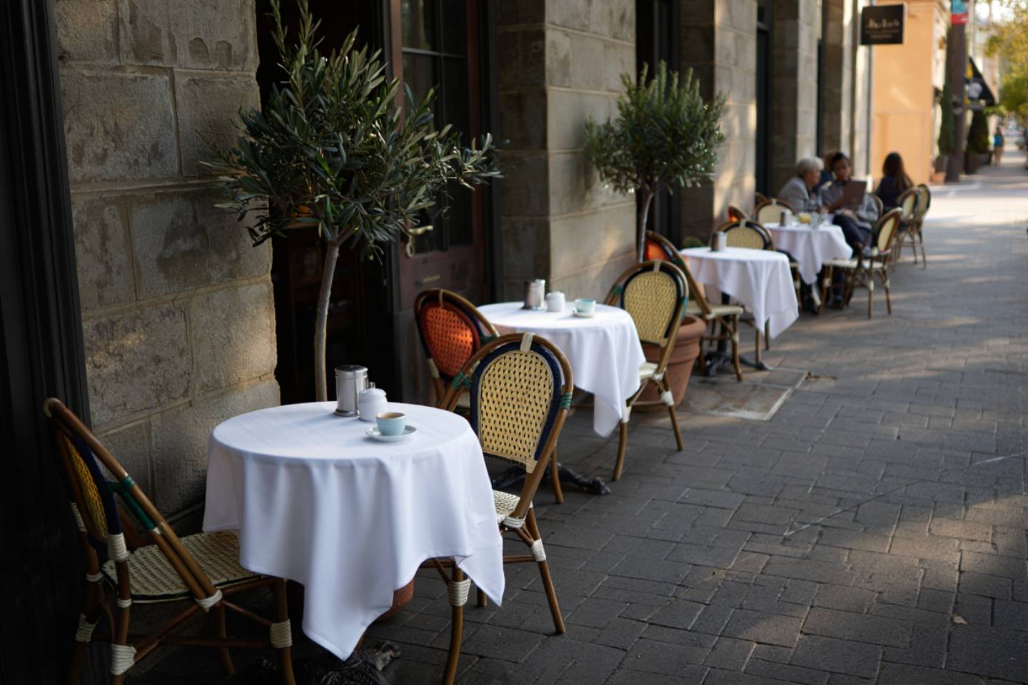 Outdoor café tables in Yountville or St. Helena during a quiet Napa Valley morning, emphasizing an unhurried breakfast experience.