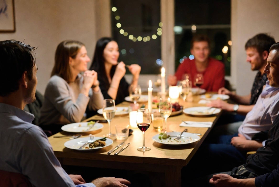 After-dinner scene with wine glasses and candles on a table, capturing conversation and the unhurried feeling of Napa Valley hospitality brought into the home.