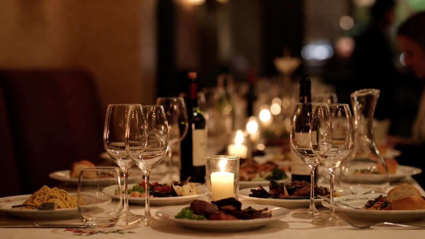 Late evening dinner table in Napa Valley with candlelight, shared plates, and wine glasses during a relaxed meal.