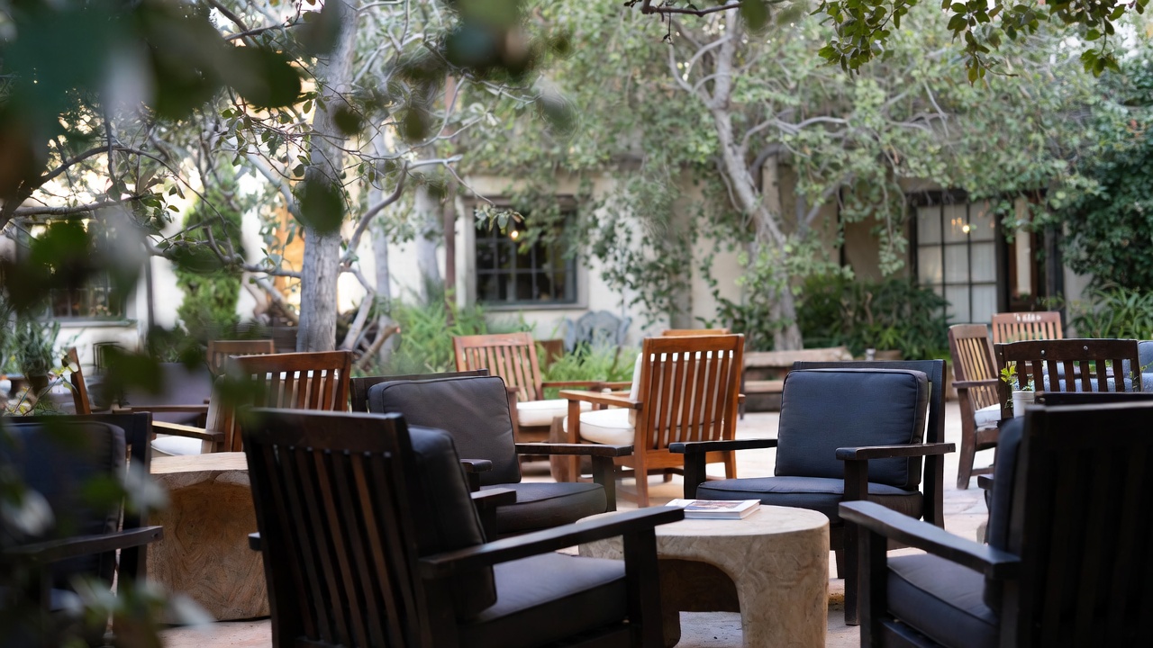  Quiet outdoor patio in Napa Valley with chairs and a book on a table, suited for reading and group discussion during a book club retreat.
