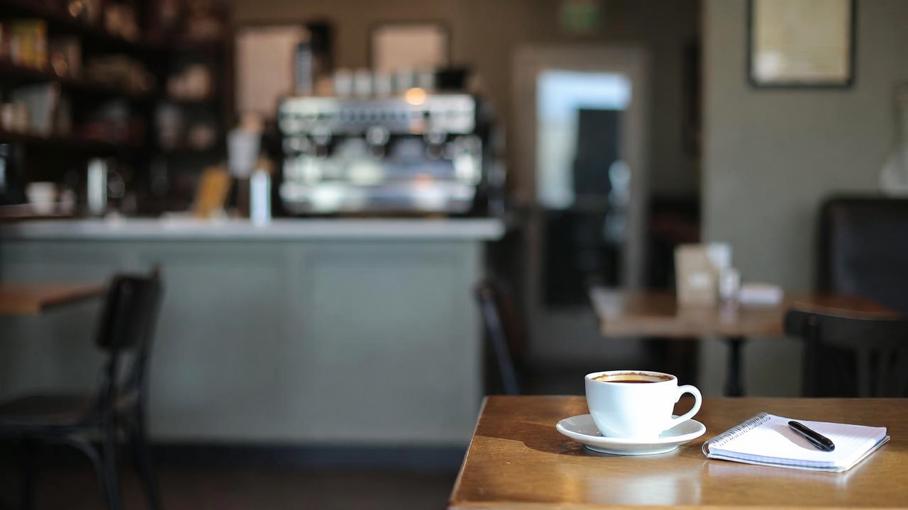 Empty table in a Napa Valley cafe with a coffee cup and notebook on a quiet weekday morning, creating a calm space for writing and creative work.
