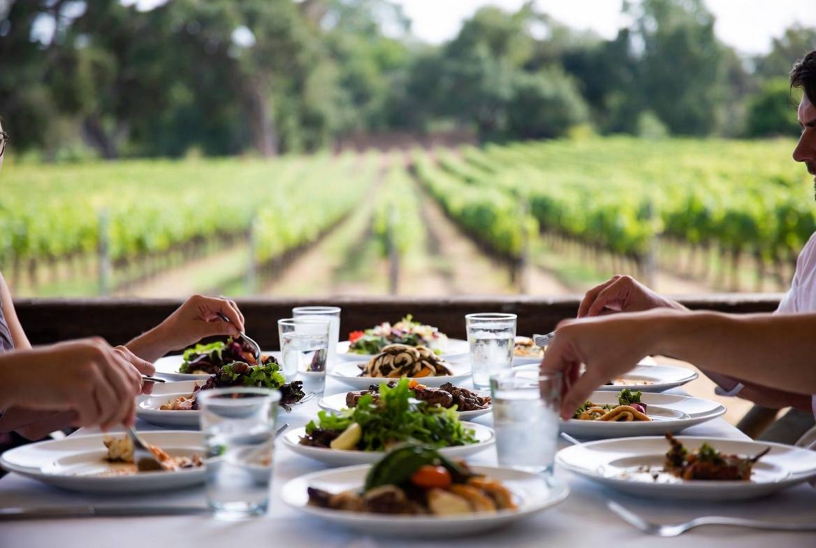 Family sharing a long outdoor meal in Napa Valley, creating connection and tradition during a relaxed wine country visit.