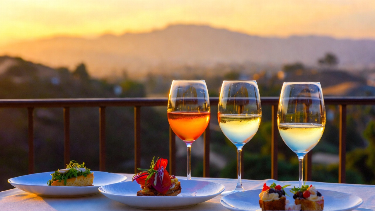A professional food photography shot of a seasonal wine pairing flight on a stone terrace in Napa Valley at sunset, with soft golden light illuminating the wine and the Mayacamas mountains in the background.