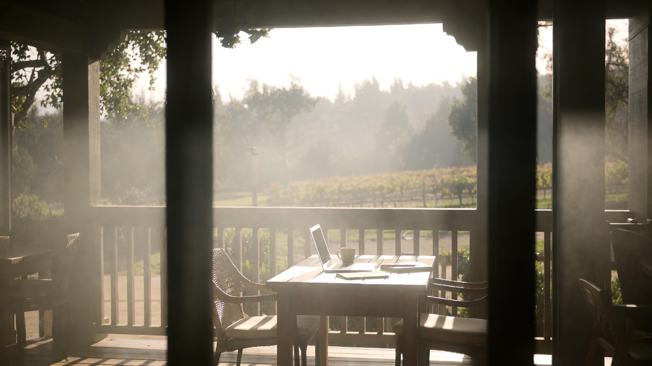  Quiet Napa Valley hotel patio in the early morning with seating and open space, offering a peaceful environment for working remotely before the day begins.