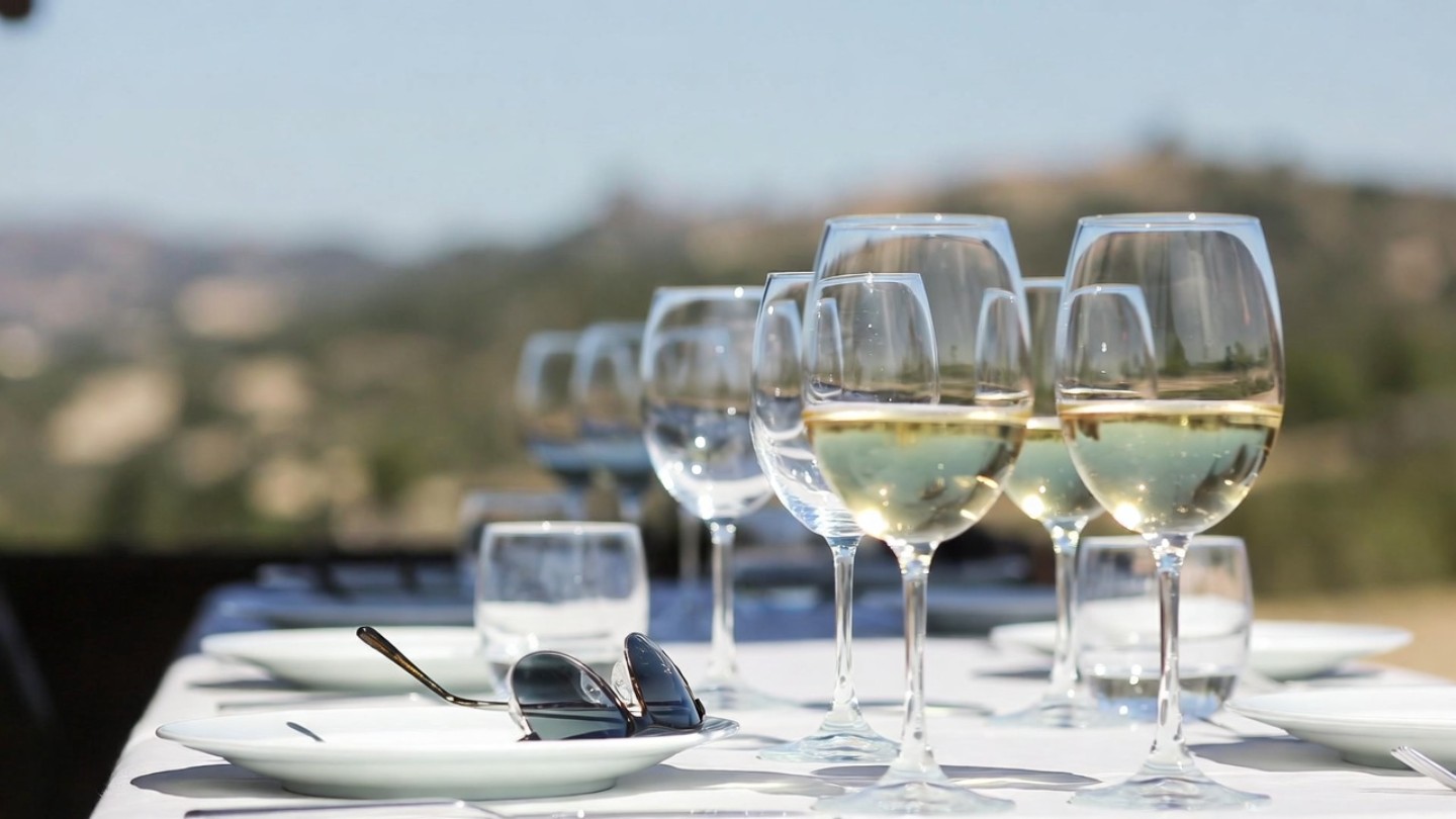 Casual outdoor lunch in Napa Valley with wine and simple food, representing relaxed travel and packing light for a wine country trip.