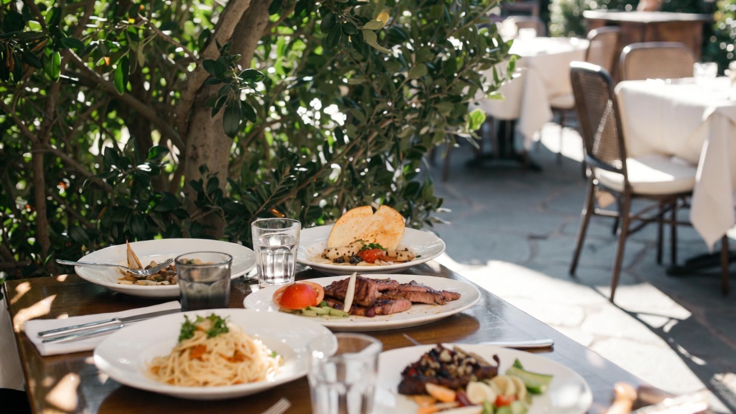 Relaxed long lunch at a Napa Valley restaurant patio with soft light and shared plates, illustrating unhurried time and connection for couples celebrating an engagement.