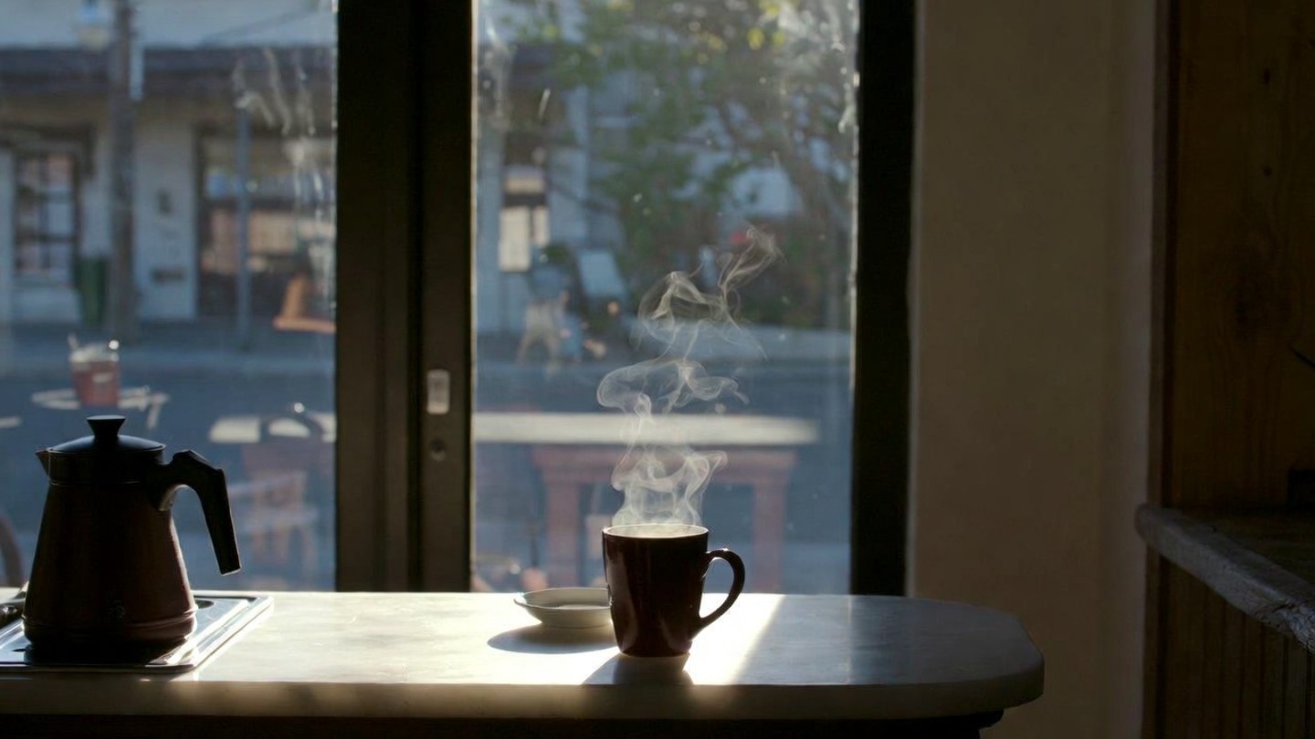 Steaming cup of coffee on a café counter in Napa Valley during early morning light, capturing the quiet breakfast ritual South Bay visitors seek before the valley wakes up.