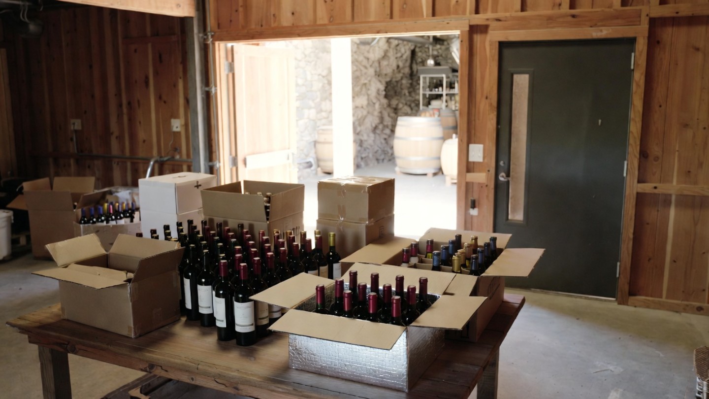 Winery staff in Napa Valley carefully packing wine bottles into insulated shipping boxes, a common practice for safely shipping wine from Napa to San Francisco.