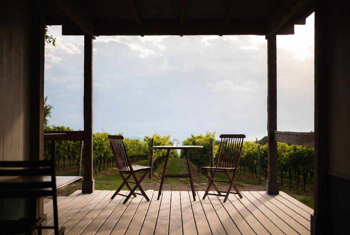 Peaceful winery terrace in Napa Valley with seating for two and vineyard views, ideal for couples on a yearly ritual trip.