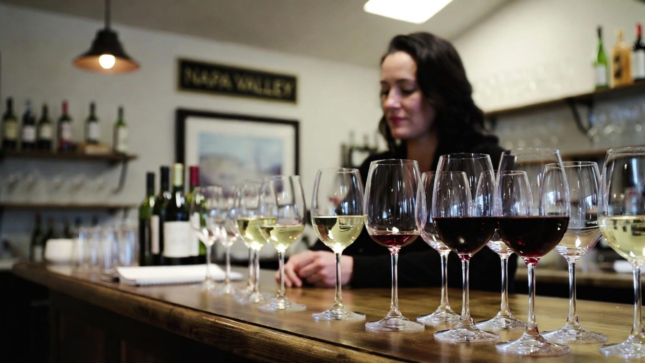 Solo guest at a Napa Valley winery tasting counter, illustrating a relaxed and personal wine tasting experience for San Francisco travelers.