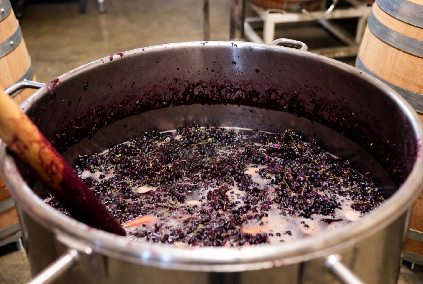 Open top fermenter with native yeast fermentation and grape skins during punch down at a Napa Valley winery in Oakville.