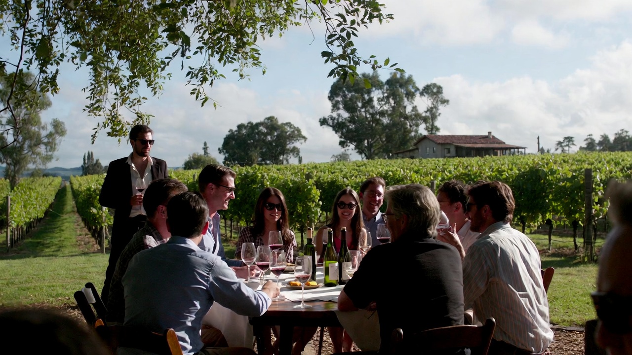A seated winery tasting in Napa Valley with guests sharing one table and talking, illustrating how wineries create a sense of community and connection.