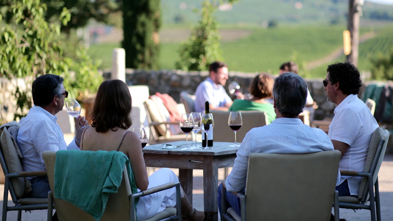 Seated winery tasting in Napa Valley with wine glasses on a table overlooking vineyards, illustrating a relaxed and unrushed wine country experience for retirees.