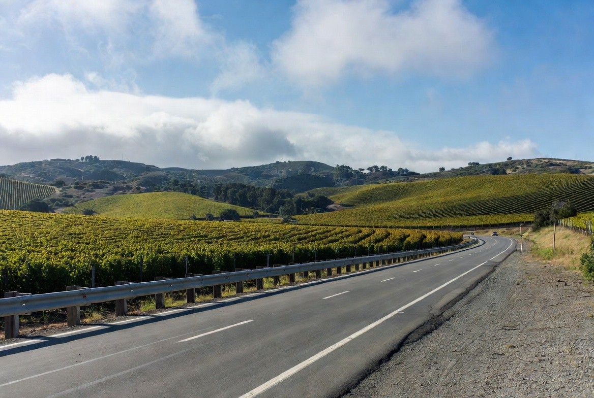 Father and son standing together in a Napa Valley winery barrel room during a production focused tasting, learning about winemaking side by side.