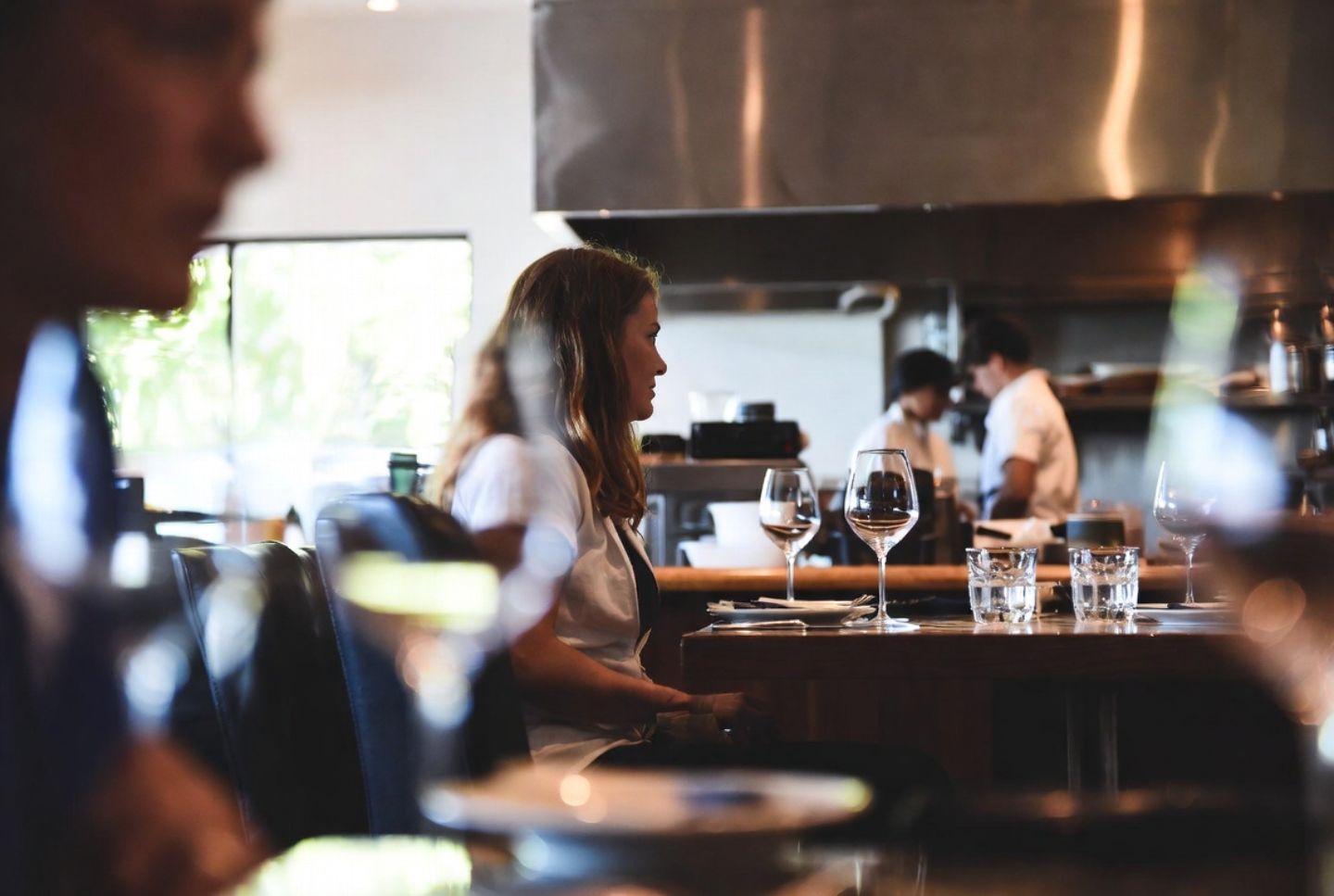 Solo diner seated at a Napa Valley restaurant bar with an open kitchen, representing food focused solo travel from San Francisco.