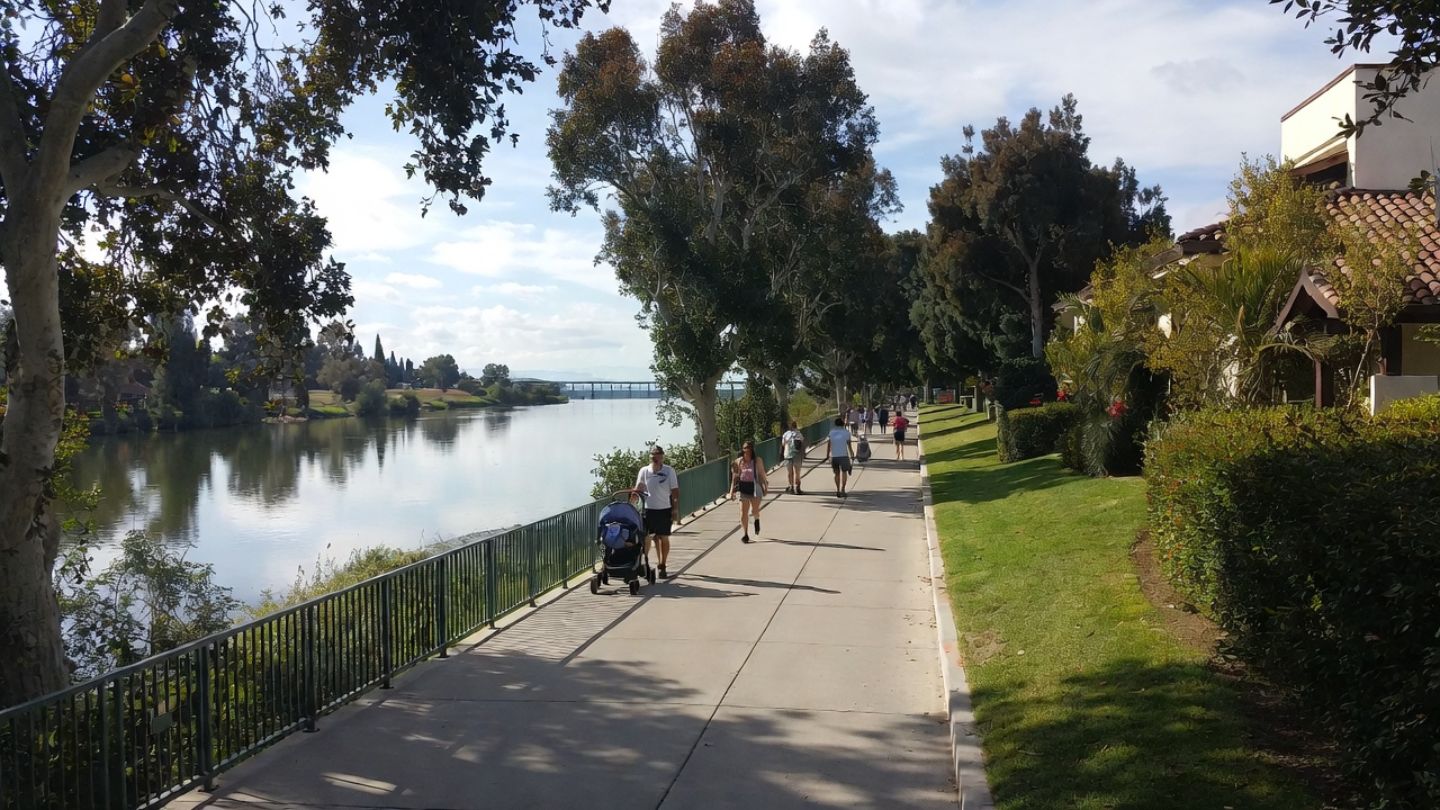 Families walking along a shaded riverfront path in South Napa, highlighting parks and outdoor spaces suitable for family friendly Napa visits.