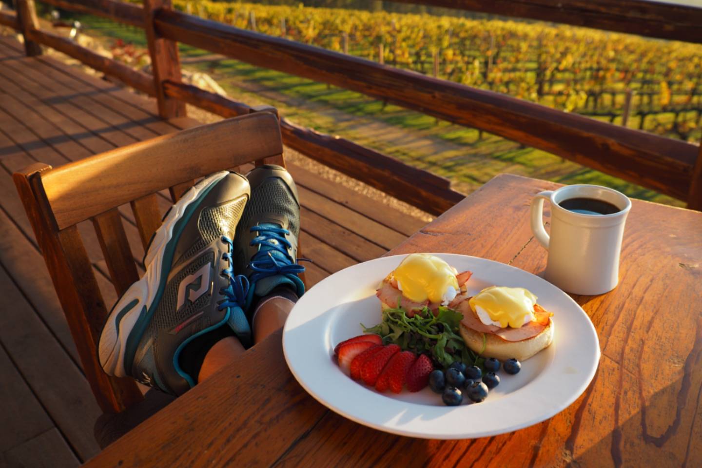 Post run breakfast with coffee on a vineyard patio in St. Helena Napa Valley with running shoes beside the table.