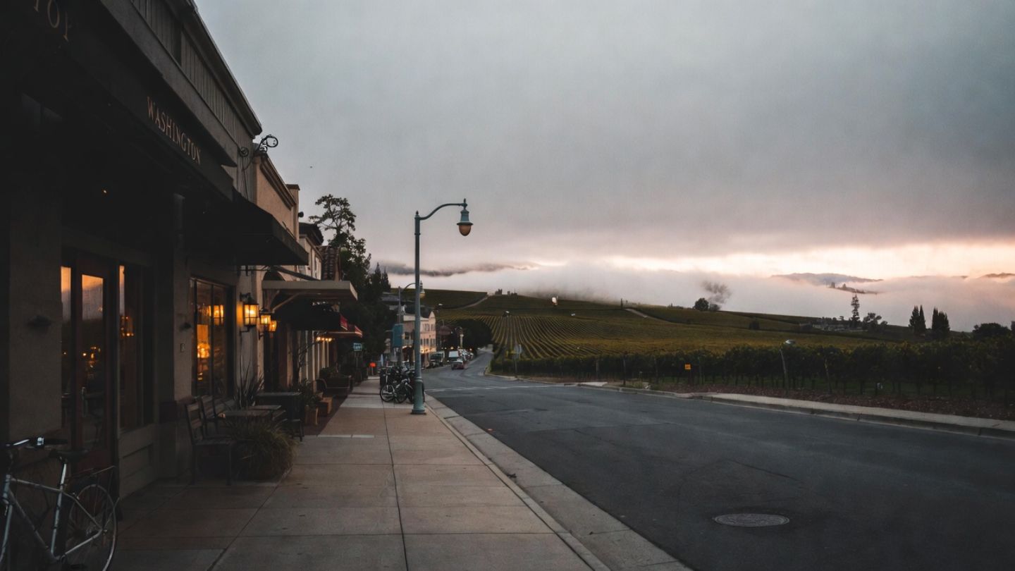 Quiet morning sidewalk in Yountville, Napa Valley, with cafés and vineyards visible, highlighting the town’s walkable layout for visitors.