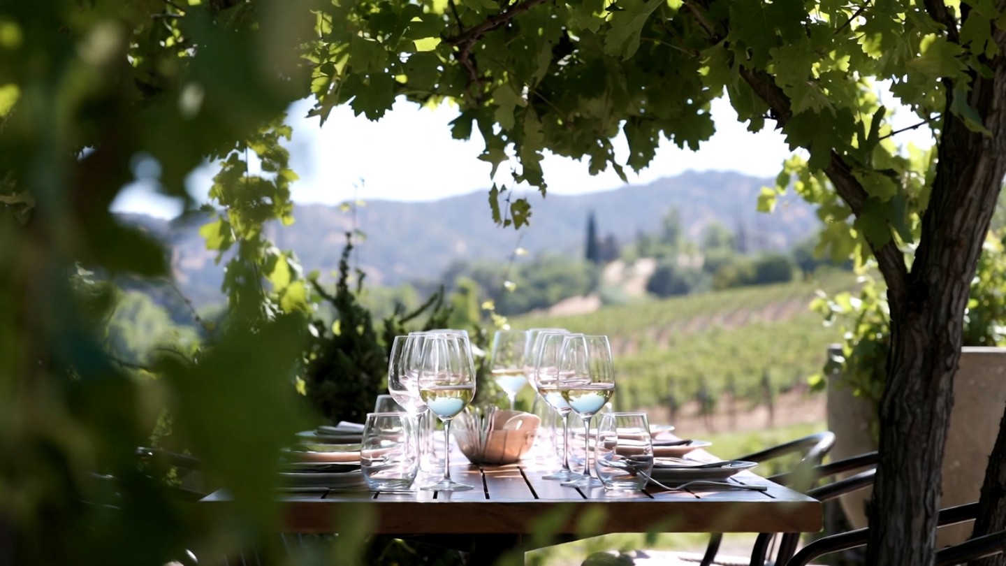 Outdoor lunch table in Yountville surrounded by trees and vineyard views, representing the relaxed midday pause during a self guided Napa Valley wine tour.